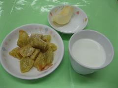 洋風大学芋と牛乳と果物の写真