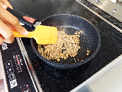 フライパンで豚ひき肉と調味料と水を入れて炒めている写真