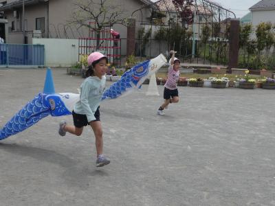 こいのぼりと走っている写真